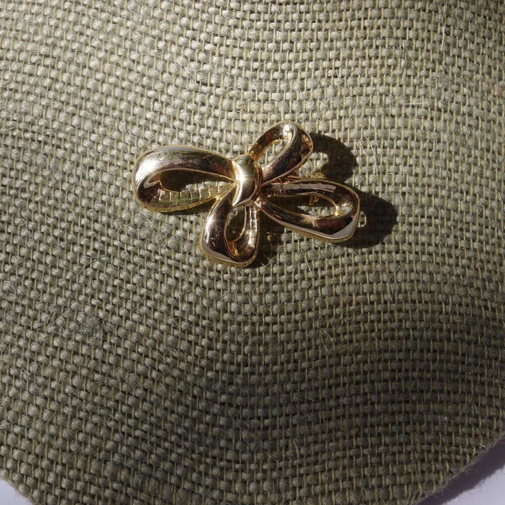 Women`s gold tone bow brooch pin. 1 1/2 inches wid